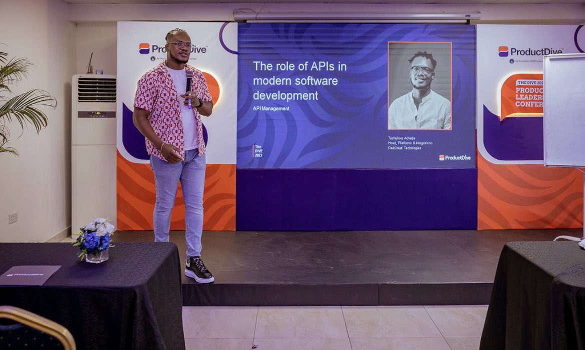 Tochii presenting on APIs in modern software development at ProductDive conference