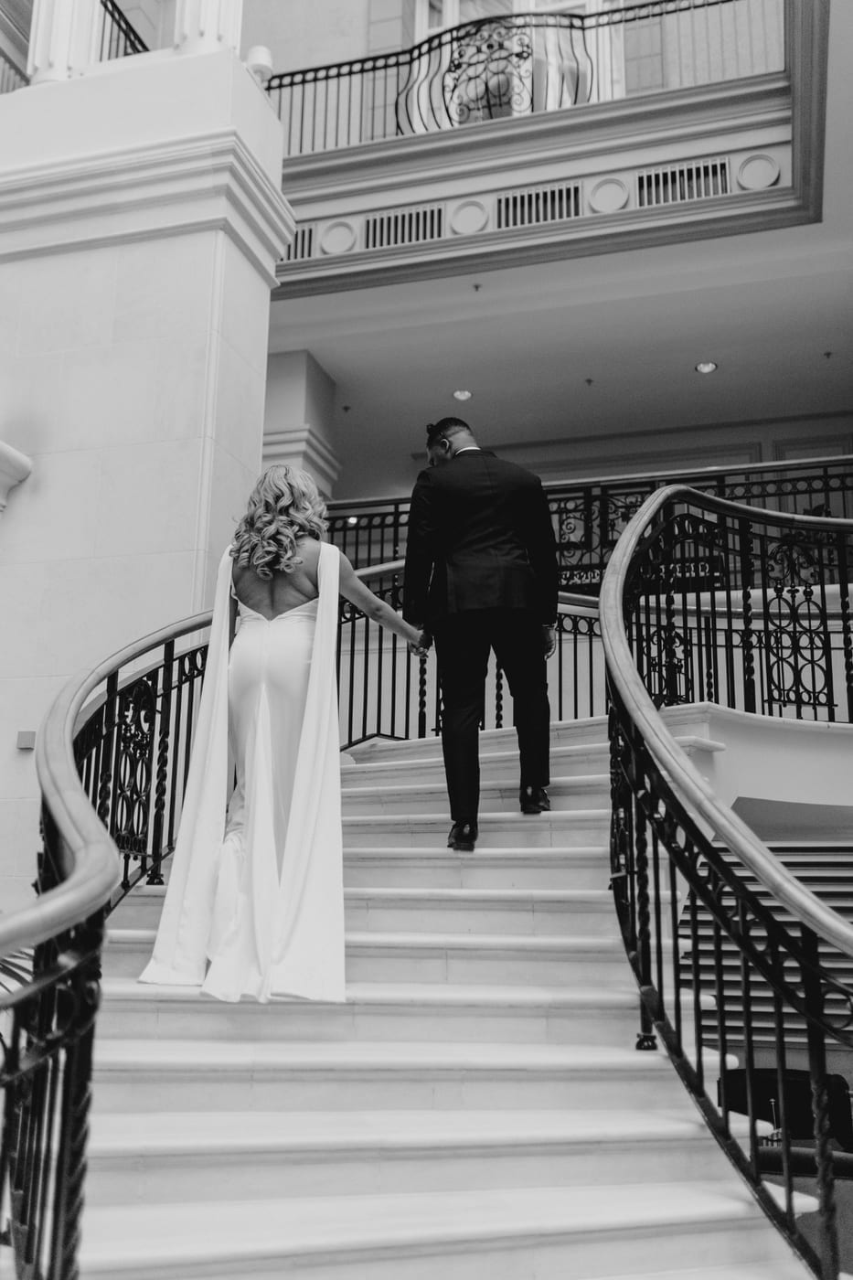 Tochii Achebe and his wife walking up a staircase on their wedding day